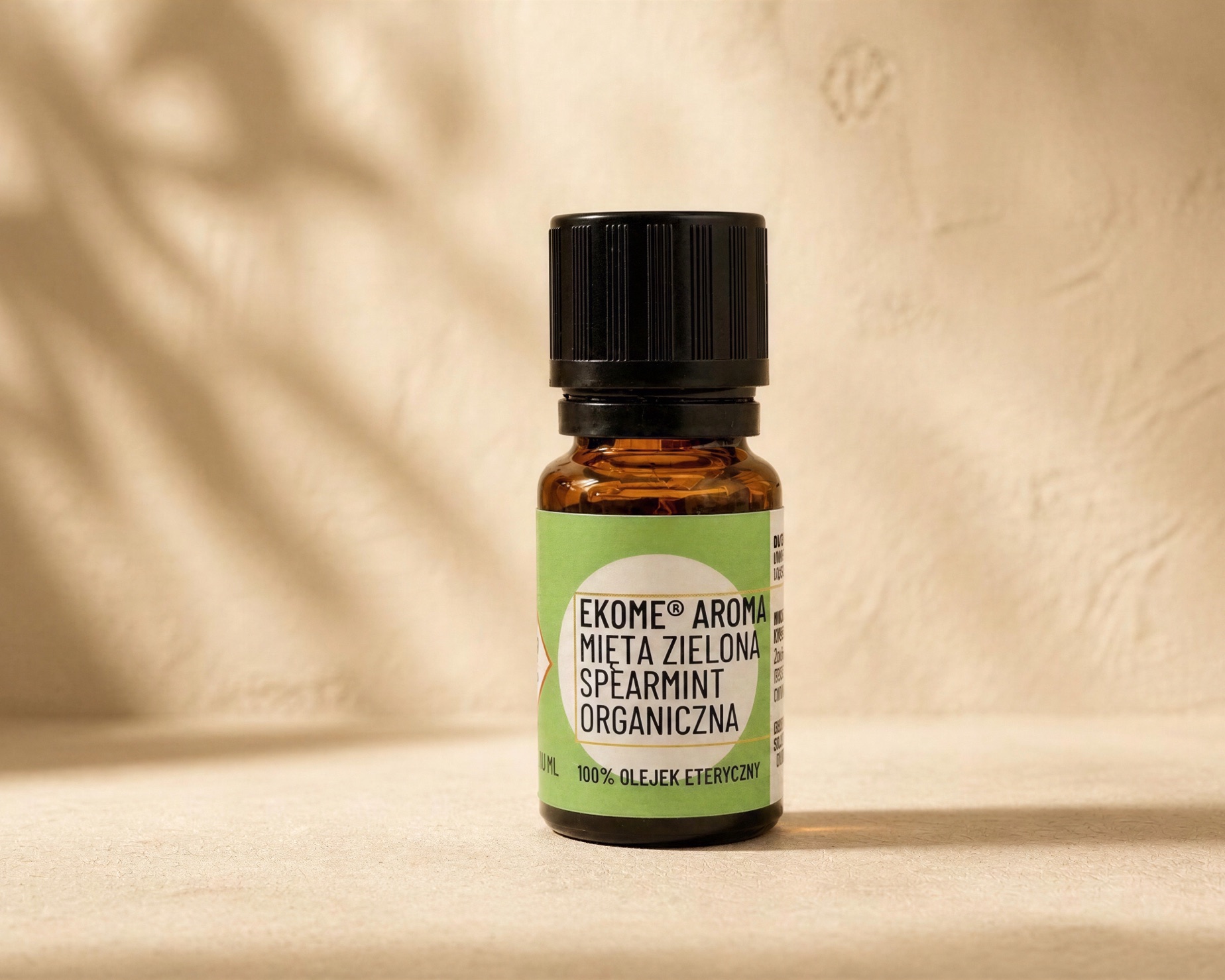 Mięta zielona Spearmint organiczny olejek eteryczny 10 ml Ekome® - kadr lifestyle Buteleczka olejku eterycznego Mięta zielona Spearmint Ekome® 10 ml w ciepłym kadrze lifestyle